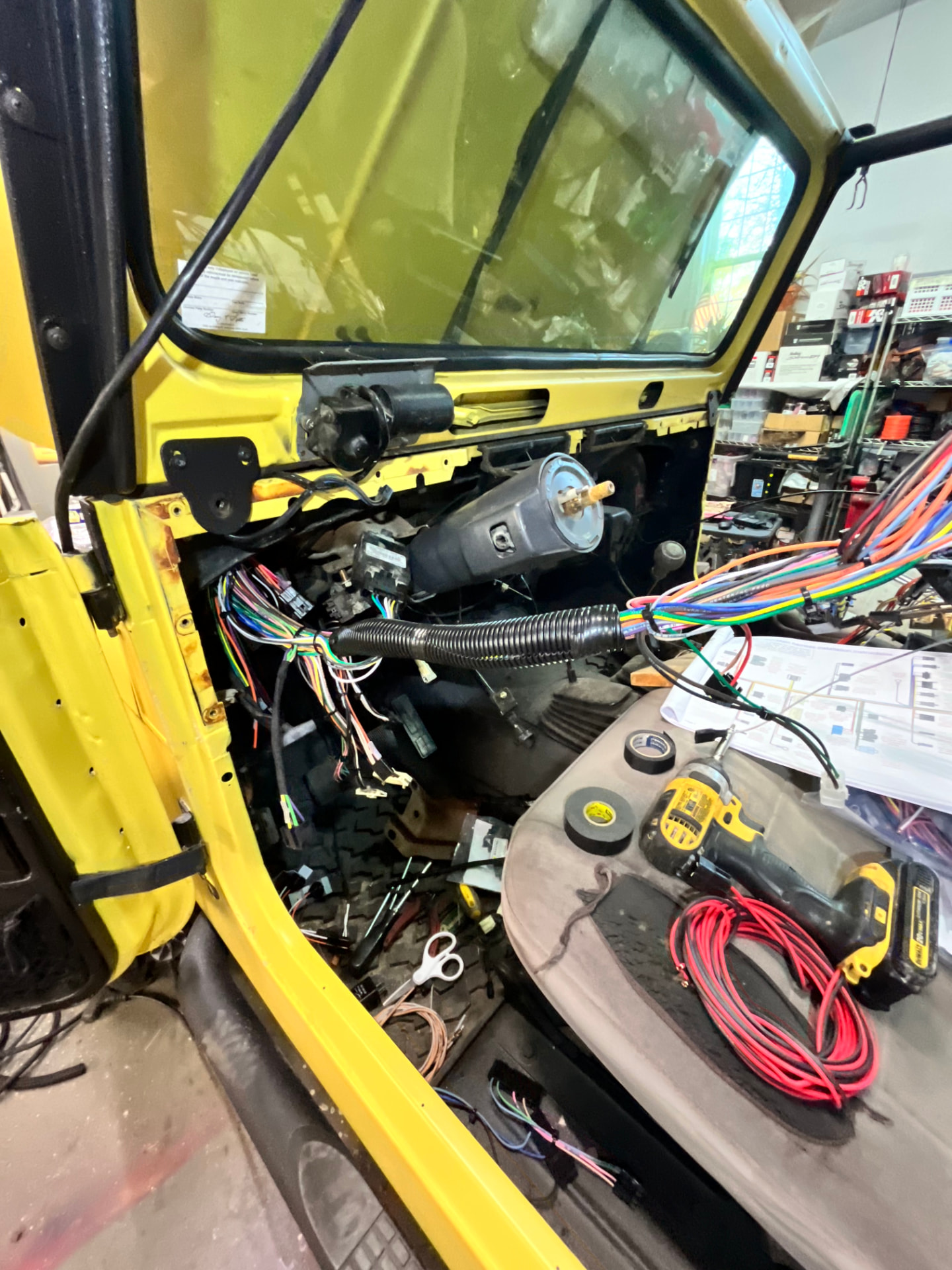 Electrical wiring and diagnostics work inside a yellow Jeep at EFJ
